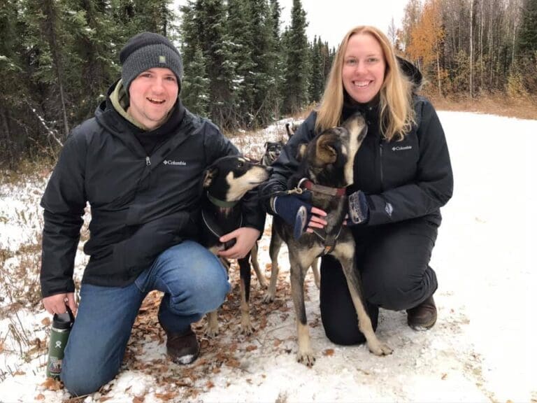A couple with two sled dogs in Alaska